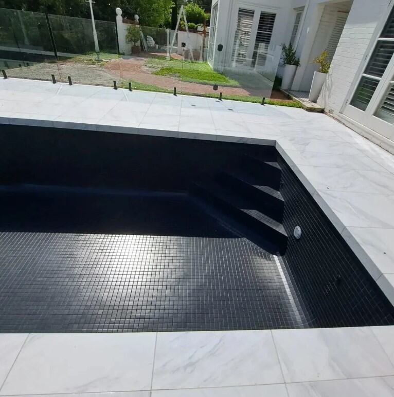 Luxurious pool with a marble finish and sleek black tiling in Penrith.