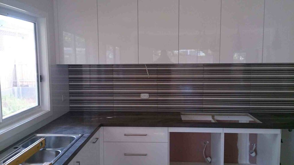 Modern Penrith kitchen featuring a stone backsplash with earthy tones installed by professional tilers